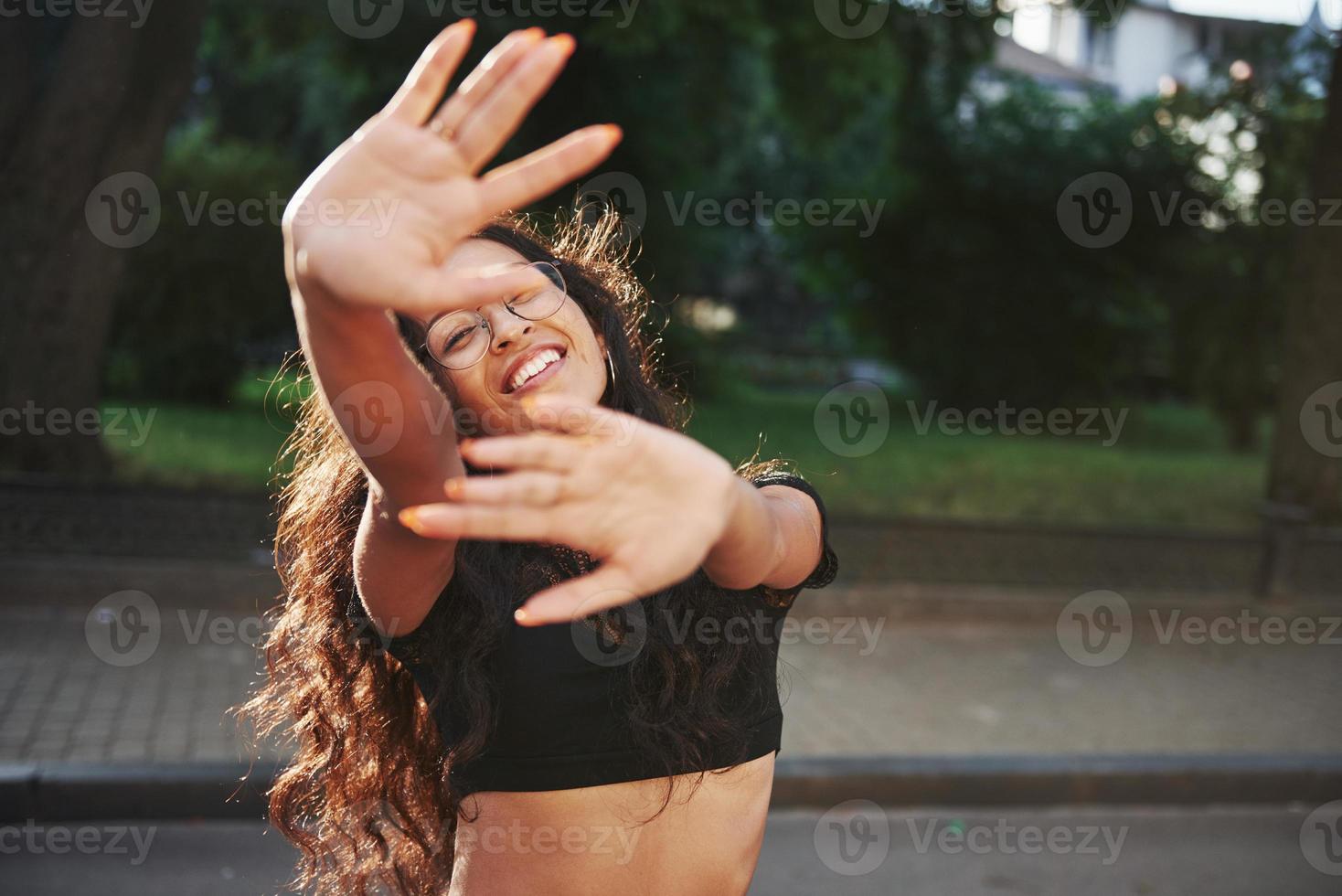 temps de printemps. belle femme aux cheveux noirs bouclés dans la ville pendant la journée photo