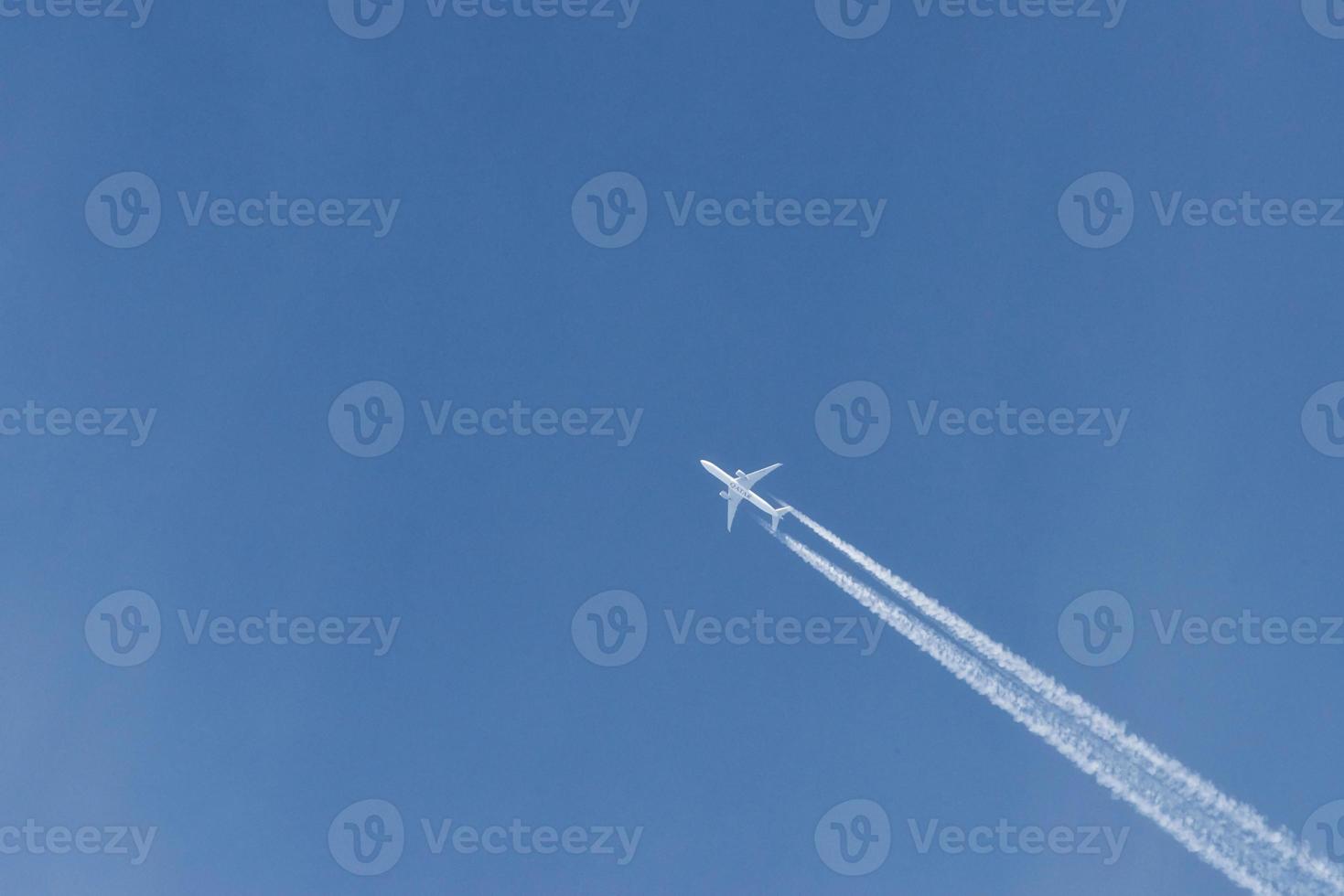 avion moderne volant haut dans le ciel bleu à la journée ensoleillée. vitesse et énergie photo