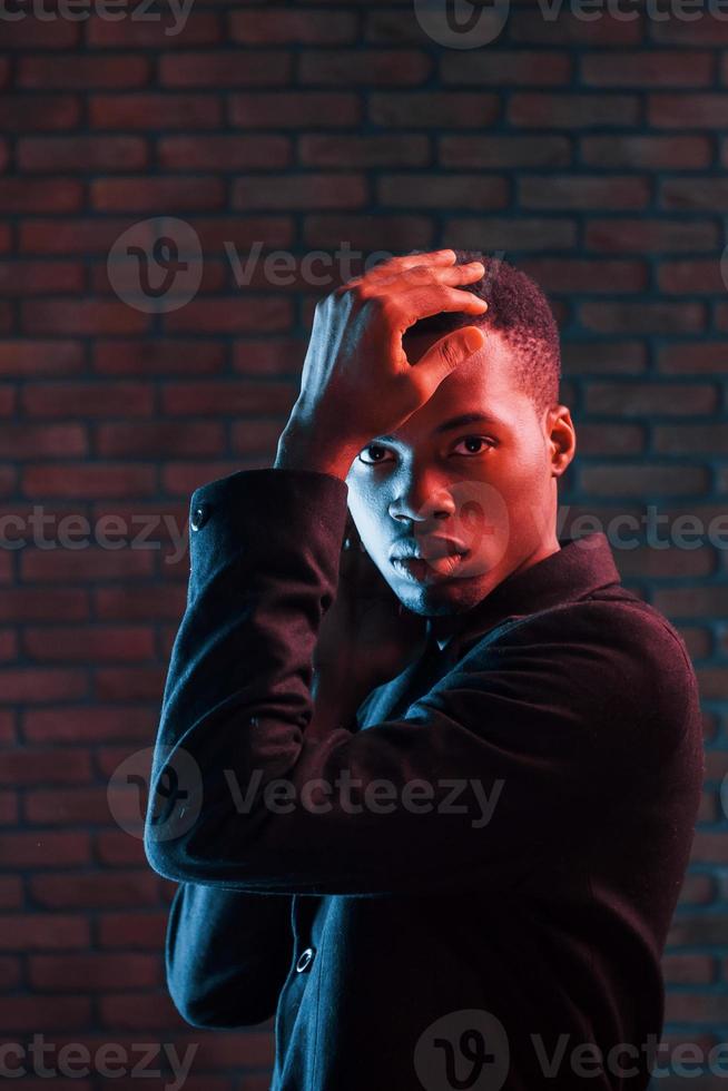 éclairage néon futuriste. jeune homme afro-américain dans le studio photo