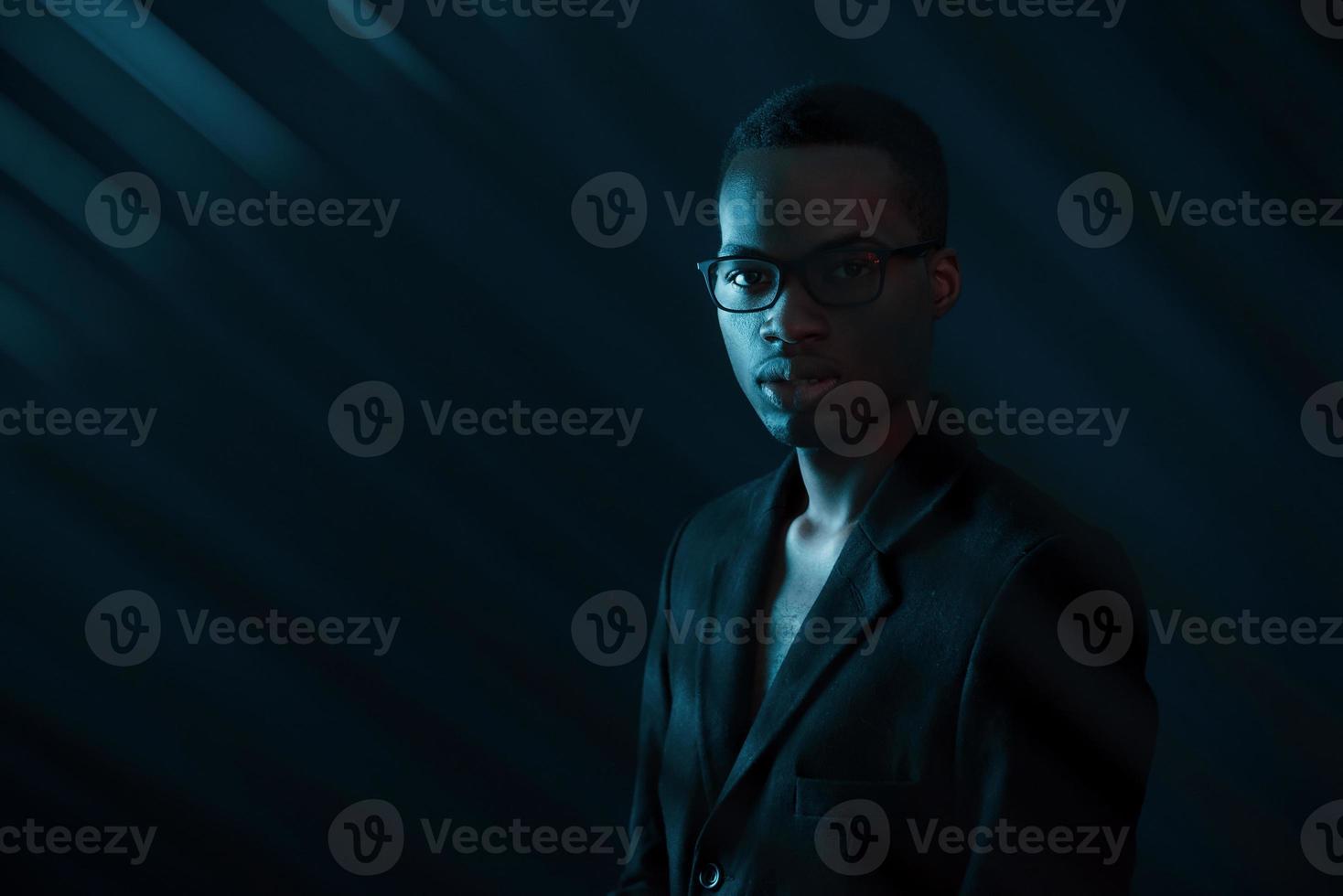 faisceaux intéressants. éclairage néon futuriste. jeune homme afro-américain dans le studio photo
