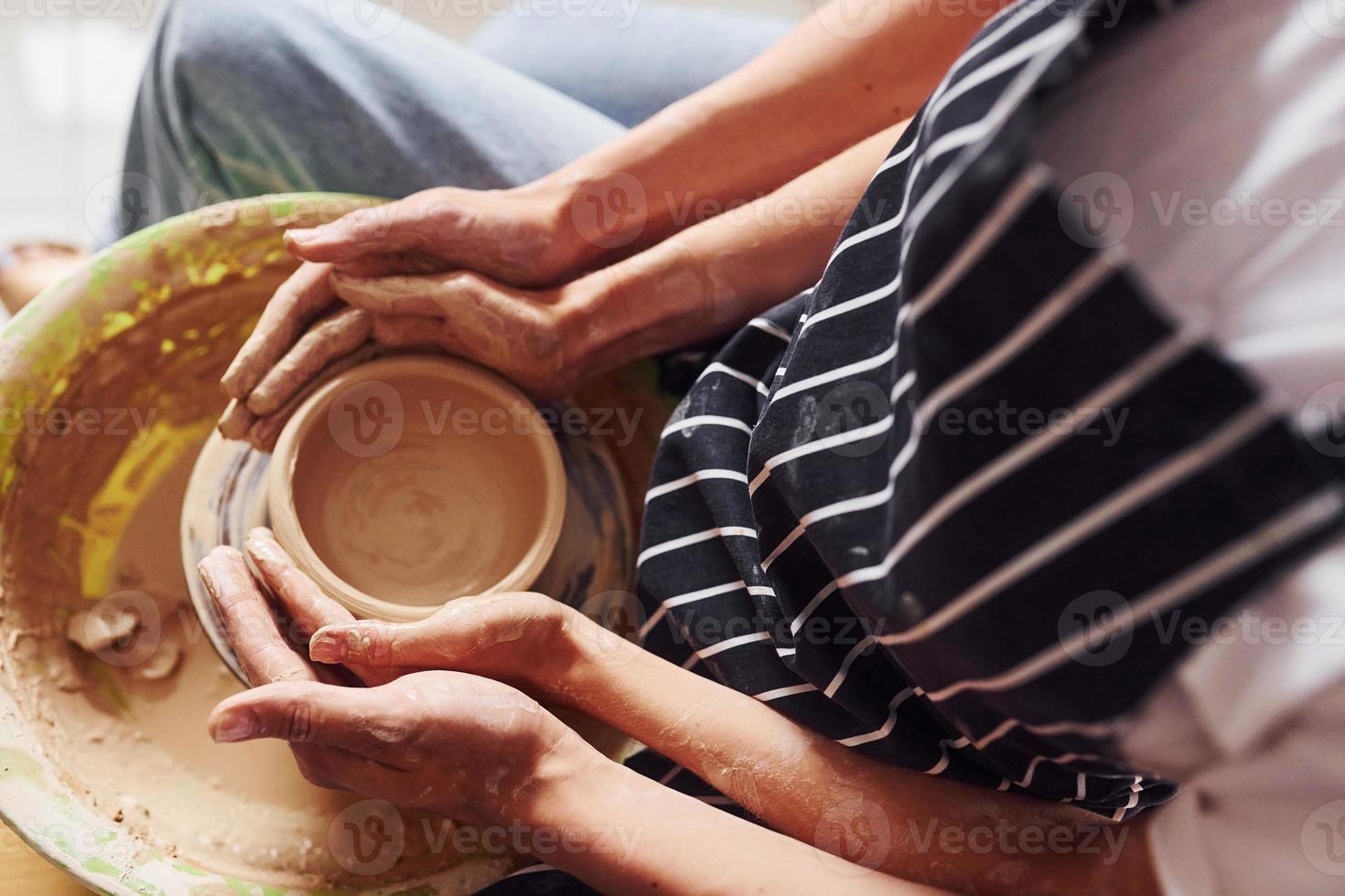 vue de dessus. avec son petit ami ou son mari. jeune femme céramiste à l'intérieur avec un produit en argile fait main. conception de la poterie photo