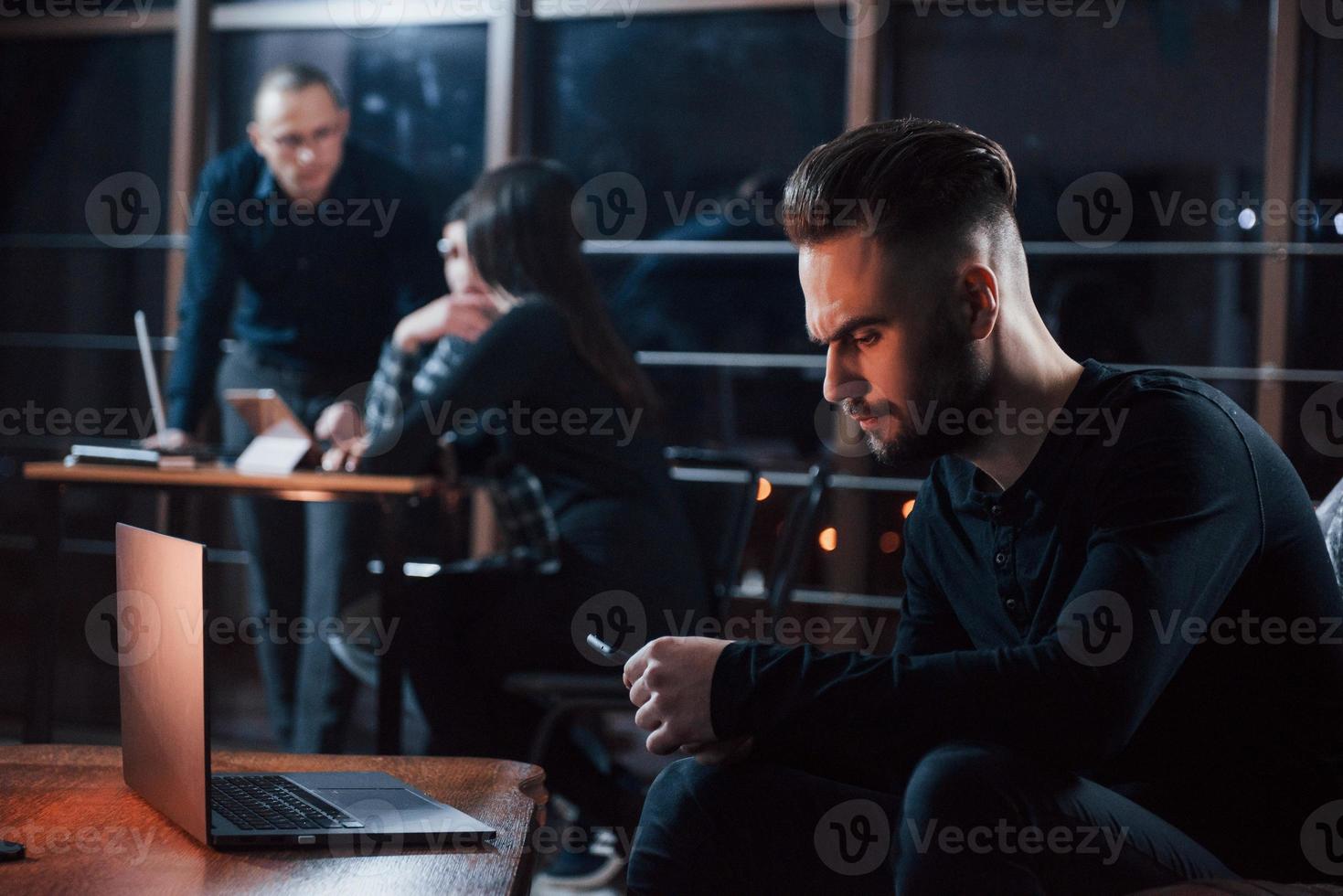 pas sûr de décider, besoin d'appeler. une équipe de jeunes hommes d'affaires travaille sur leur projet la nuit au bureau photo