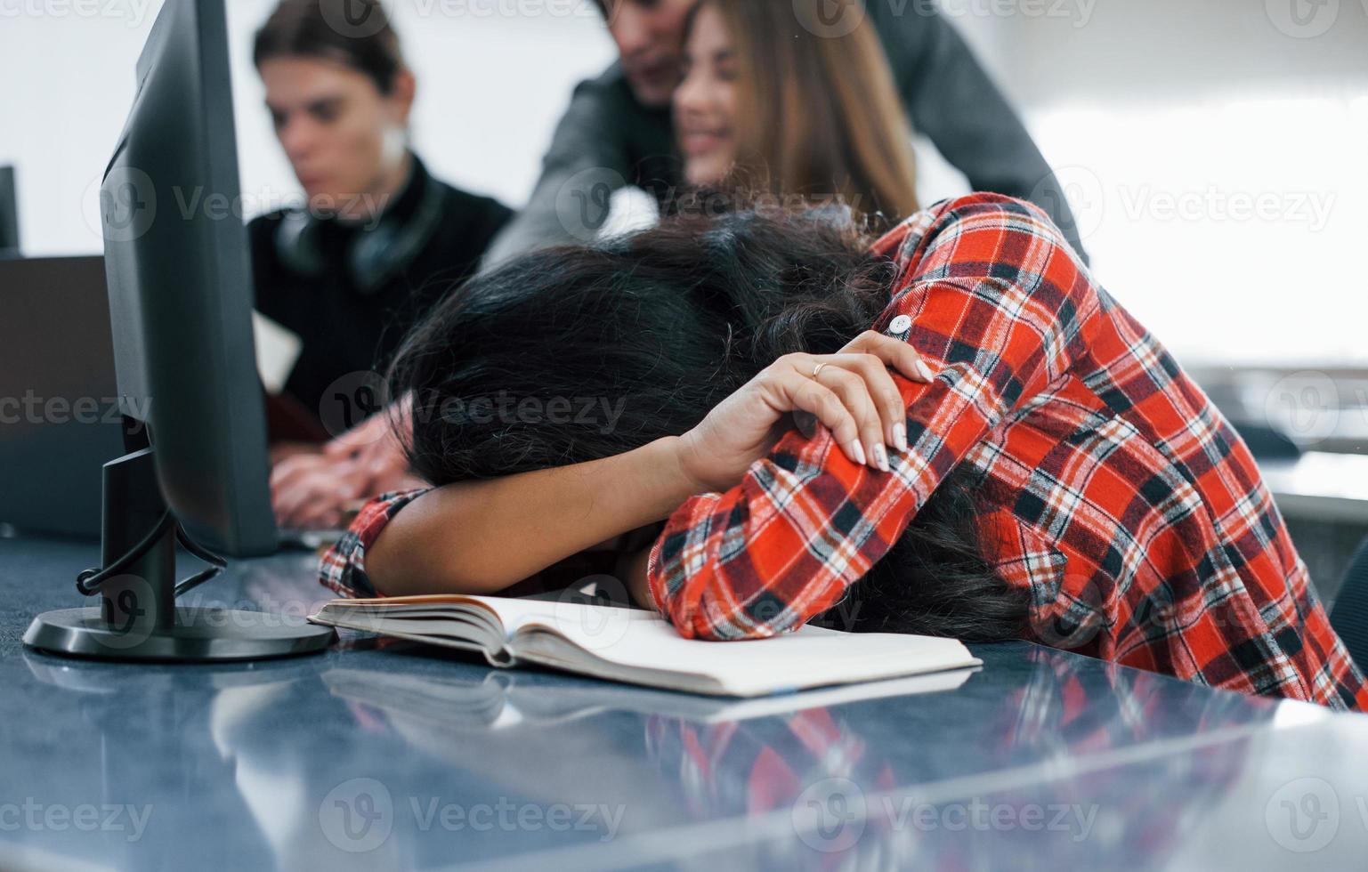 besoin de dormir. groupe de jeunes en vêtements décontractés travaillant dans le bureau moderne photo