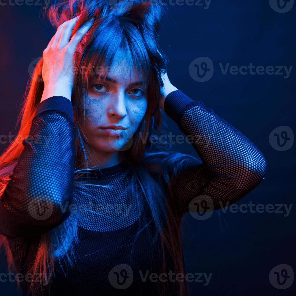 belle coupe de cheveux. studio tourné en studio sombre avec néon. portrait de jeune fille photo