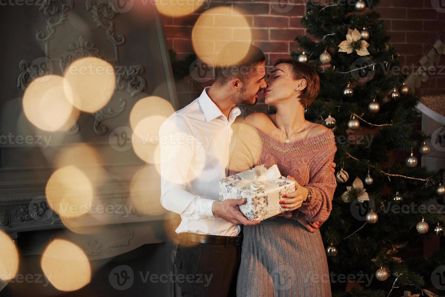 vue de face. cadeau de noël pour la femme. monsieur en costume classique donne à sa femme le cadeau photo