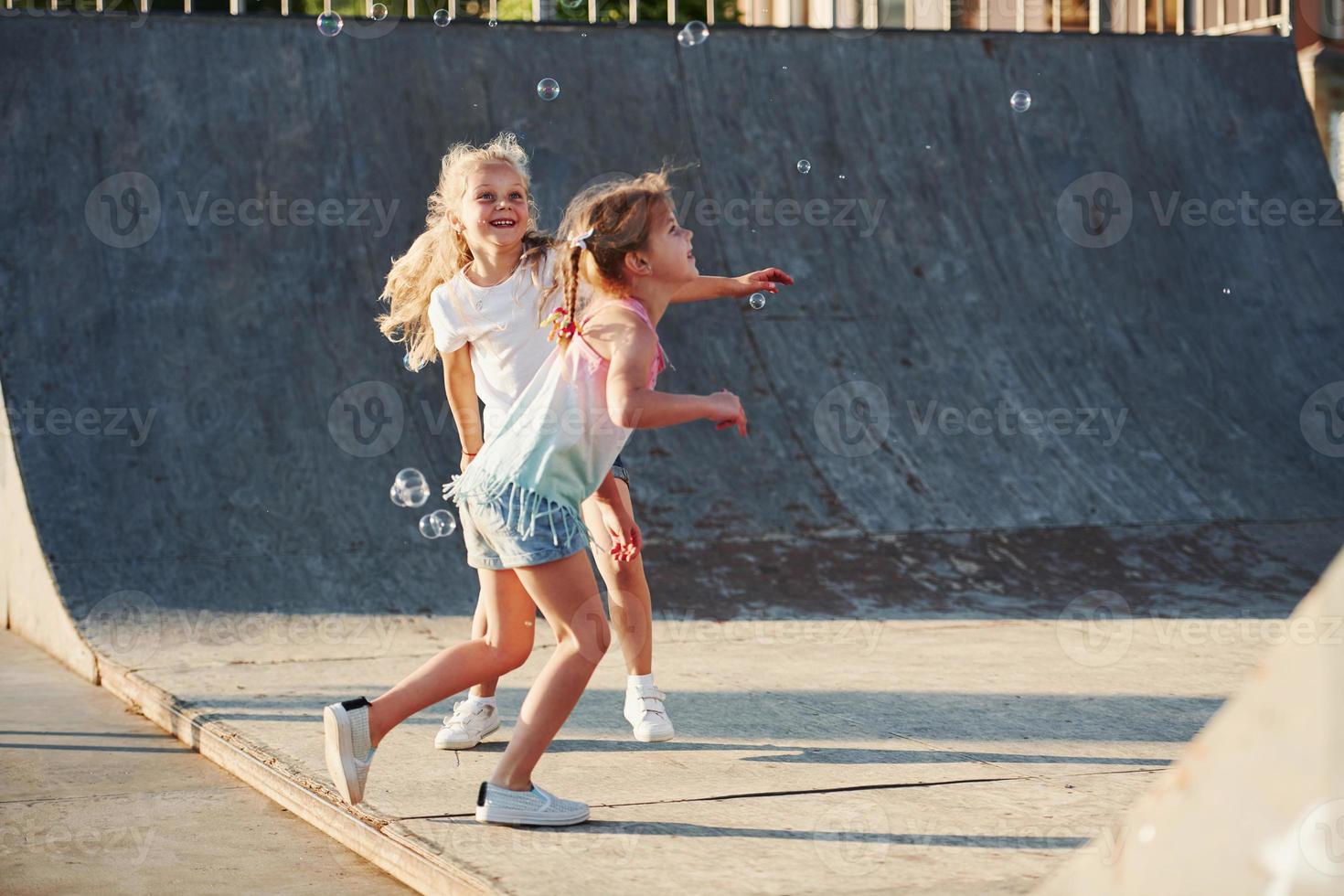 s'amuser avec des bulles. loisirs. deux petites filles s'amusant dans le parc photo