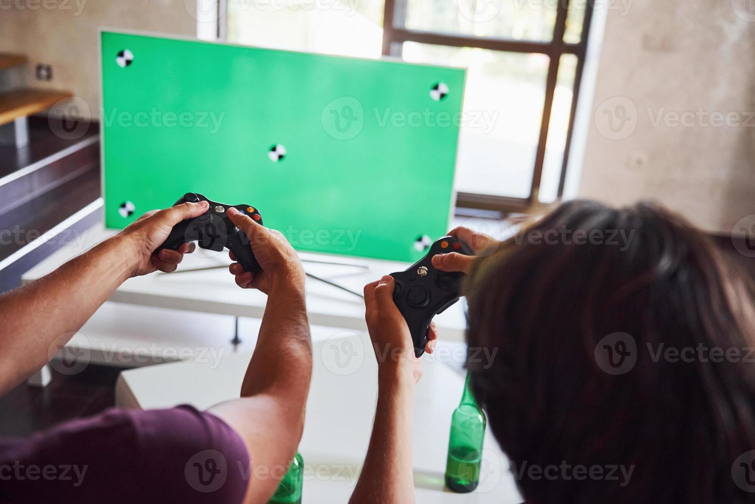 un groupe d'amis s'amuse à jouer à un jeu de console à l'intérieur dans le salon photo