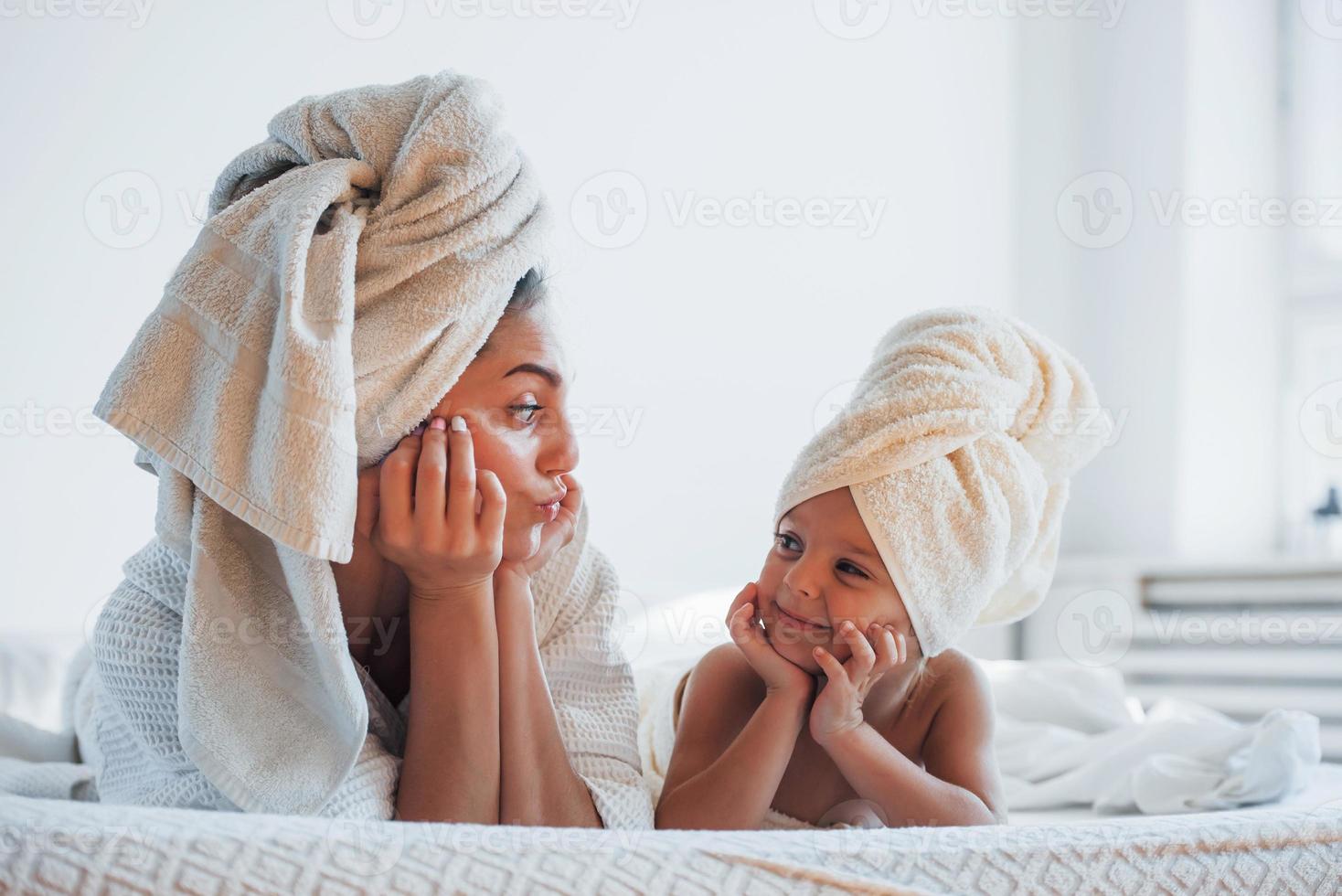 s'amuser. jeune mère avec sa fille a une journée de beauté à l'intérieur dans une salle blanche photo