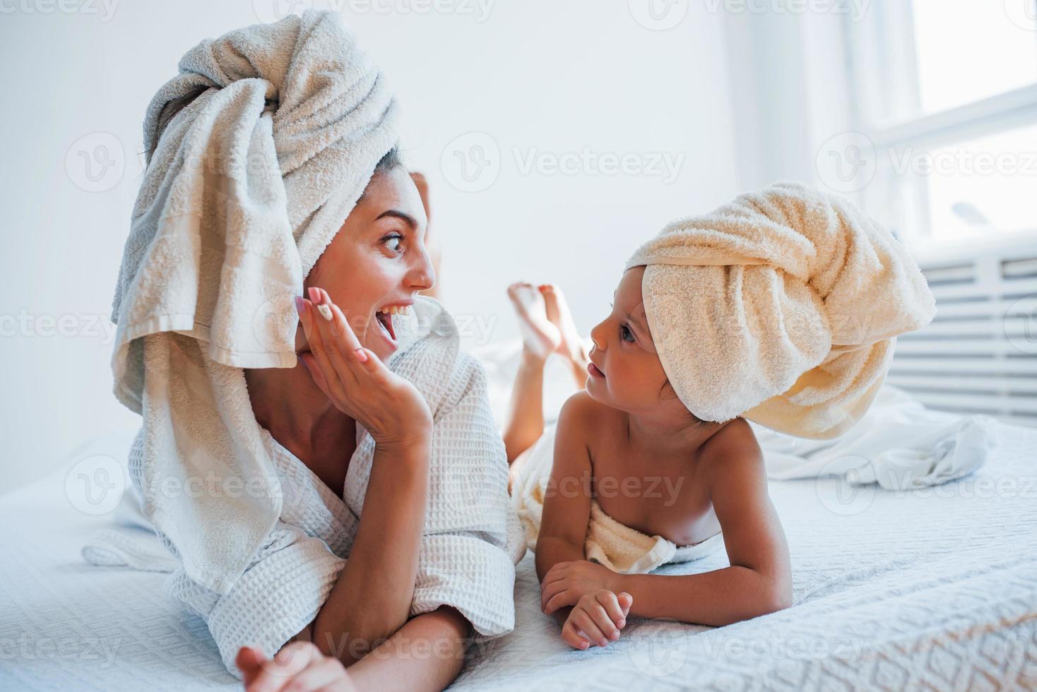 s'amuser. jeune mère avec sa fille a une journée de beauté à l'intérieur dans une salle blanche photo