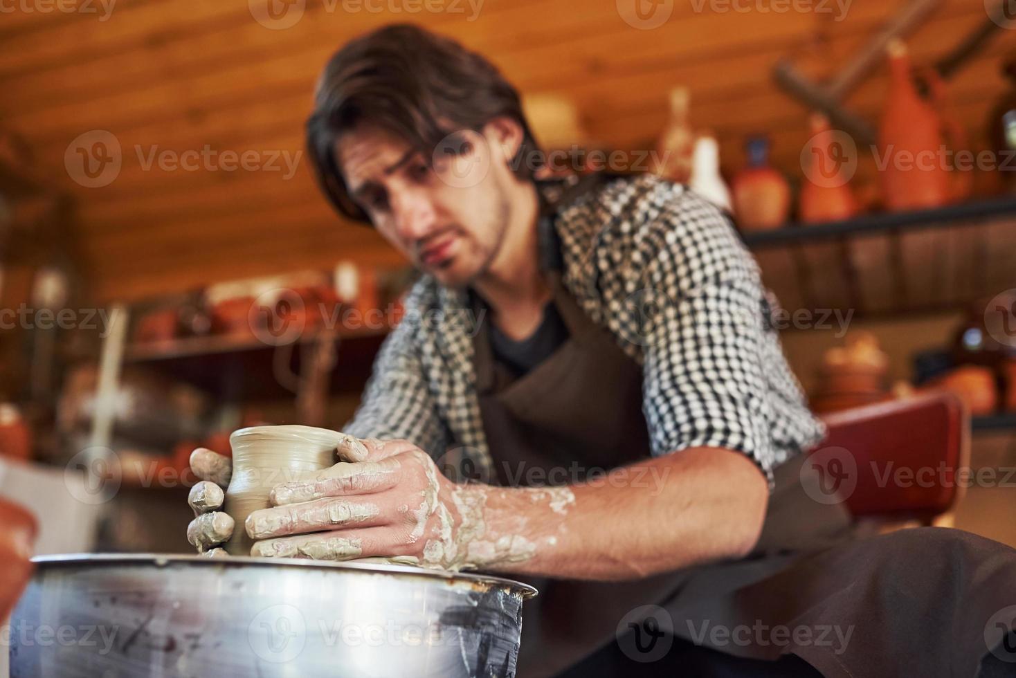 un céramiste utilise un tour de potier et crée un produit en argile fait à la main photo