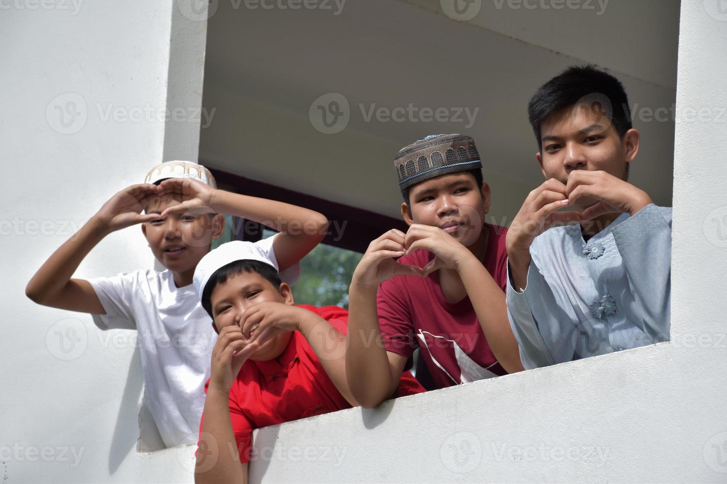 les garçons musulmans ou islamiques asiatiques montrent un mini coeur avec leurs doigts et leurs mains pour montrer l'amour et le bonheur à tout le monde concept, mise au point douce et sélective. photo