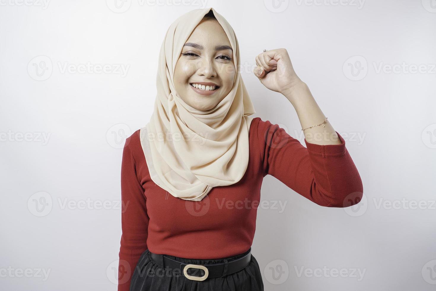 Une jeune femme musulmane asiatique avec une expression réussie heureuse portant un hijab isolé par fond blanc photo