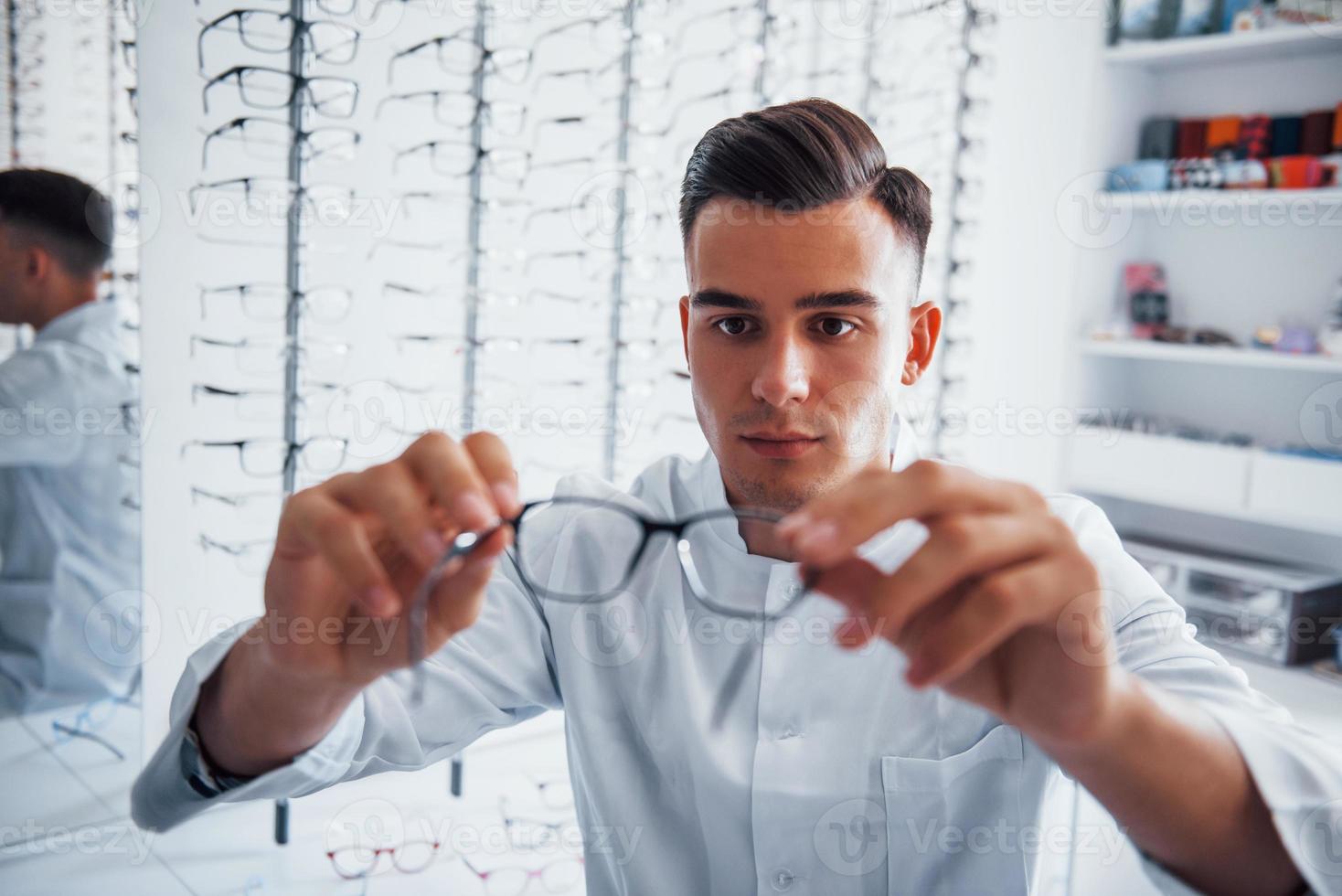 photo focalisée de nouvelles lunettes tenues par le jeune oculiste à l'intérieur