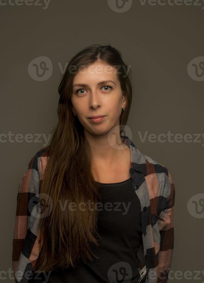 portrait d'une fille sur fond gris avec de longs cheveux photo