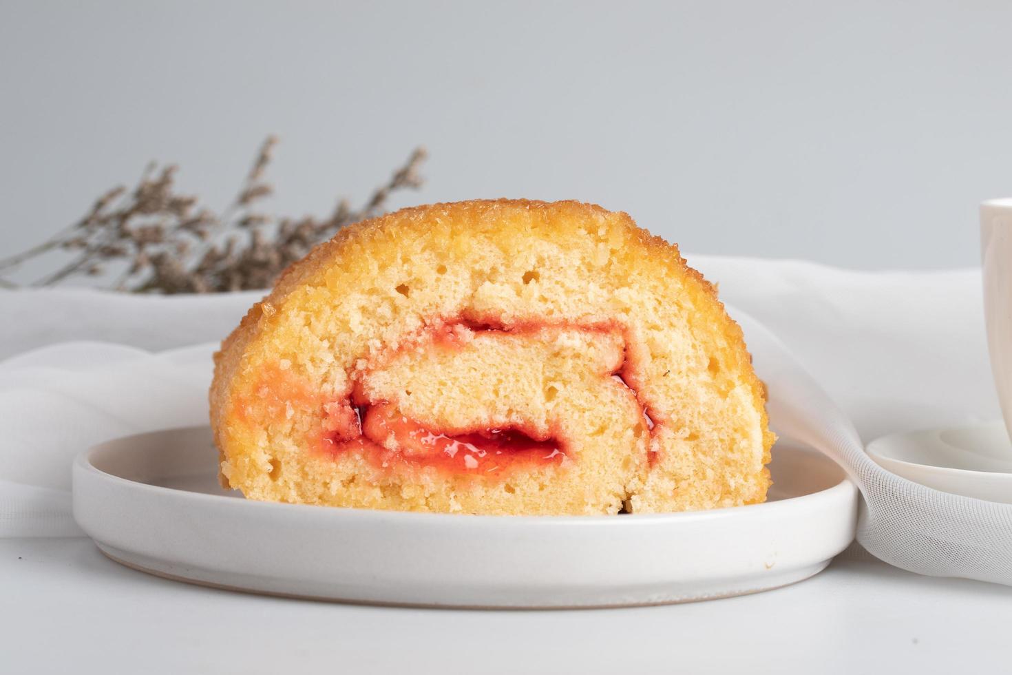 Gâteau roulé aux fraises sur fond blanc photo