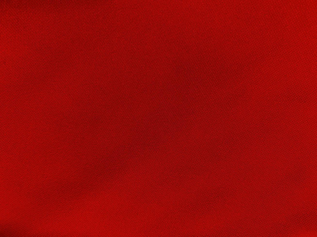 texture de tissu de coton rouge utilisée comme arrière-plan. fond de tissu rouge vide de matière textile douce et lisse. il y a de l'espace pour le texte.. photo