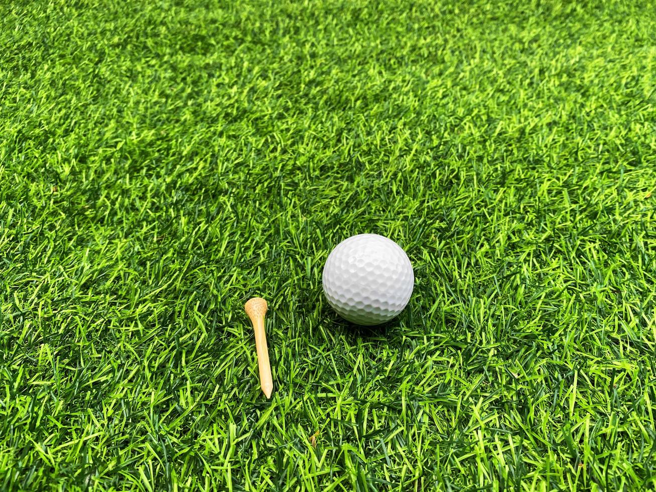 balle de golf en gros plan sur l'herbe verte sur un magnifique paysage flou de fond de golf. concept de sport international qui s'appuie sur des compétences de précision pour la relaxation de la santé. photo