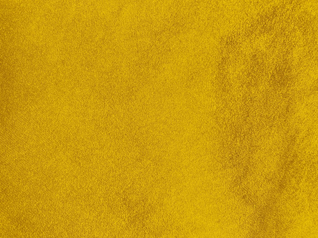 texture de tissu de velours jaune utilisée comme arrière-plan. fond de tissu jaune vide de matière textile douce et lisse. il y a de l'espace pour le texte. photo