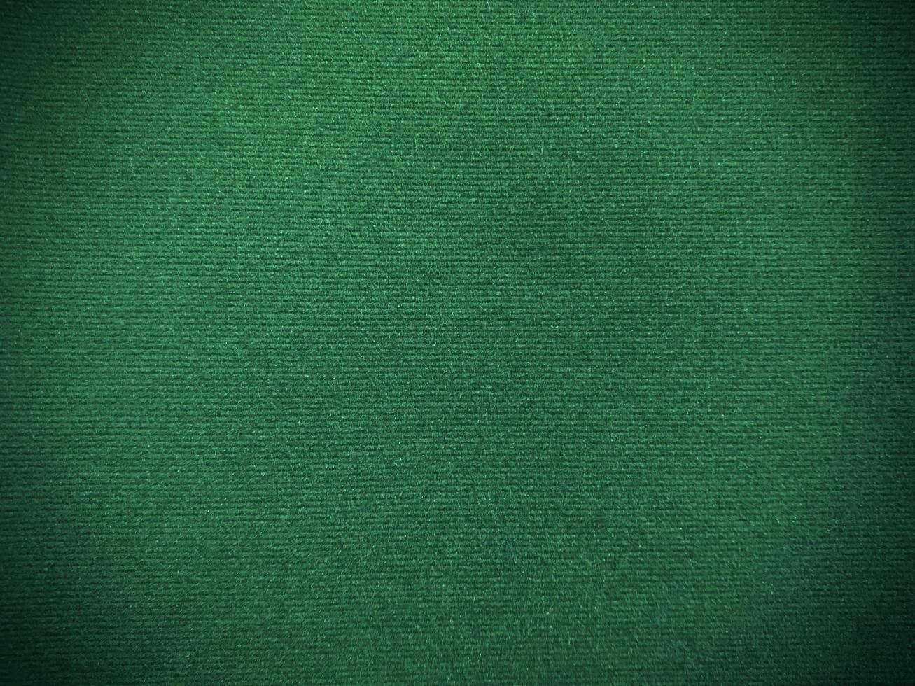 texture de tissu de velours vert foncé utilisée comme arrière-plan. fond de tissu vert vide de matière textile douce et lisse. il y a de l'espace pour le texte. photo