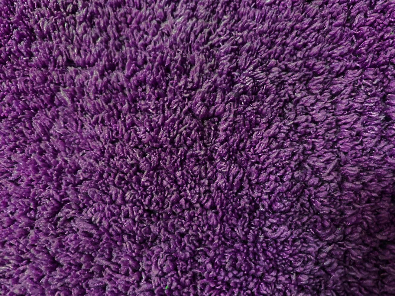 fond de texture de laine propre violet. laine de mouton naturelle légère. coton sans couture violet. texture de fourrure moelleuse pour les concepteurs. gros plan fragment de tapis de laine violette. photo