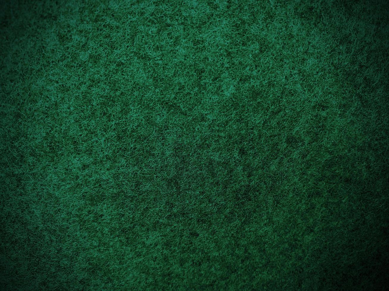 feutre vert foncé doux texture d'arrière-plan textile rugueux gros plan, table de poker, balle de tennis, nappe. fond de tissu vert vide. photo