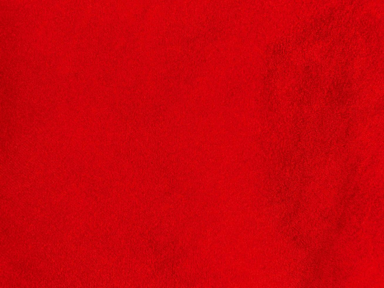 texture de tissu de velours rouge utilisée comme arrière-plan. fond de tissu rouge vide de matière textile douce et lisse. il y a de l'espace pour le texte. photo