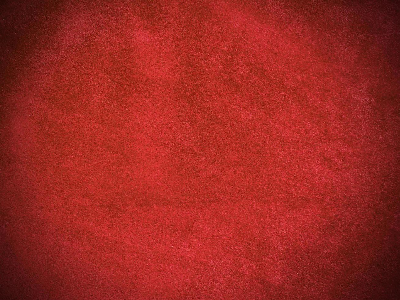 texture de tissu de velours rouge foncé utilisée comme arrière-plan. fond de tissu rouge foncé vide de matière textile douce et lisse. il y a de l'espace pour le texte. photo