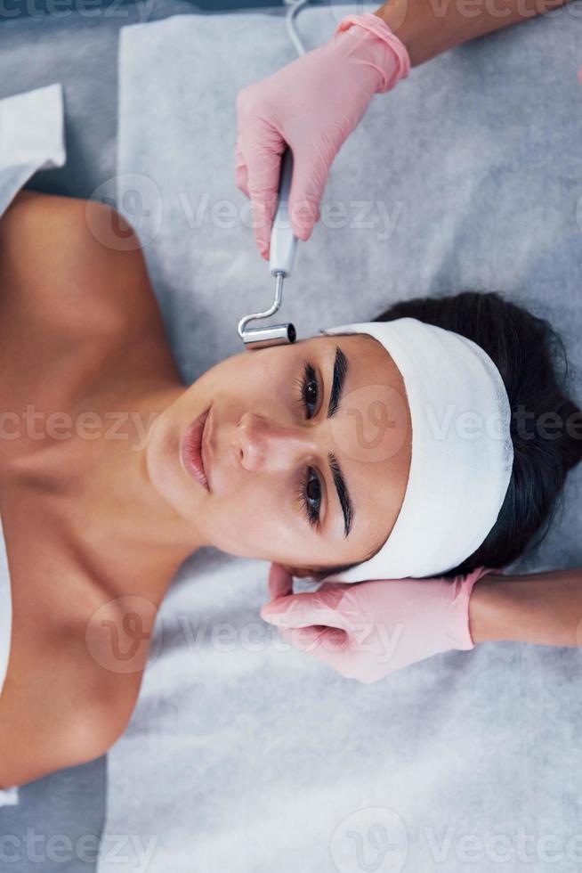 vue rapprochée d'une femme allongée dans un salon de spa et ayant une procédure de nettoyage du visage photo