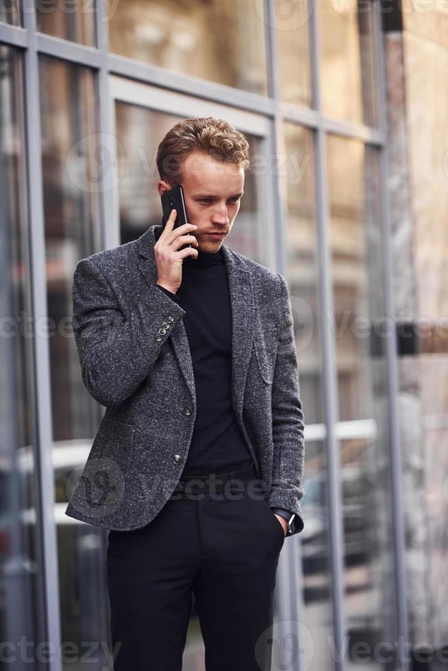 L'homme En Tenue De Soirée Élégante Et Avec Sac Est À L'extérieur Contre Un  Bâtiment Moderne. Banque D'Images et Photos Libres De Droits. Image  157645597