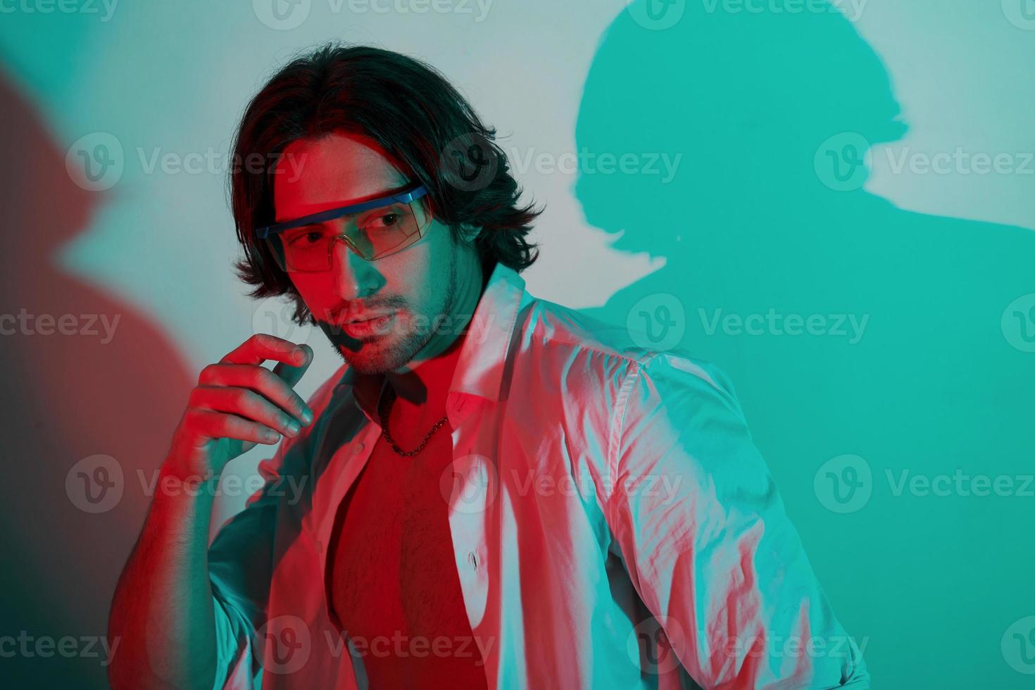 portrait de jeune homme élégant qui se tient dans des néons dans le studio photo