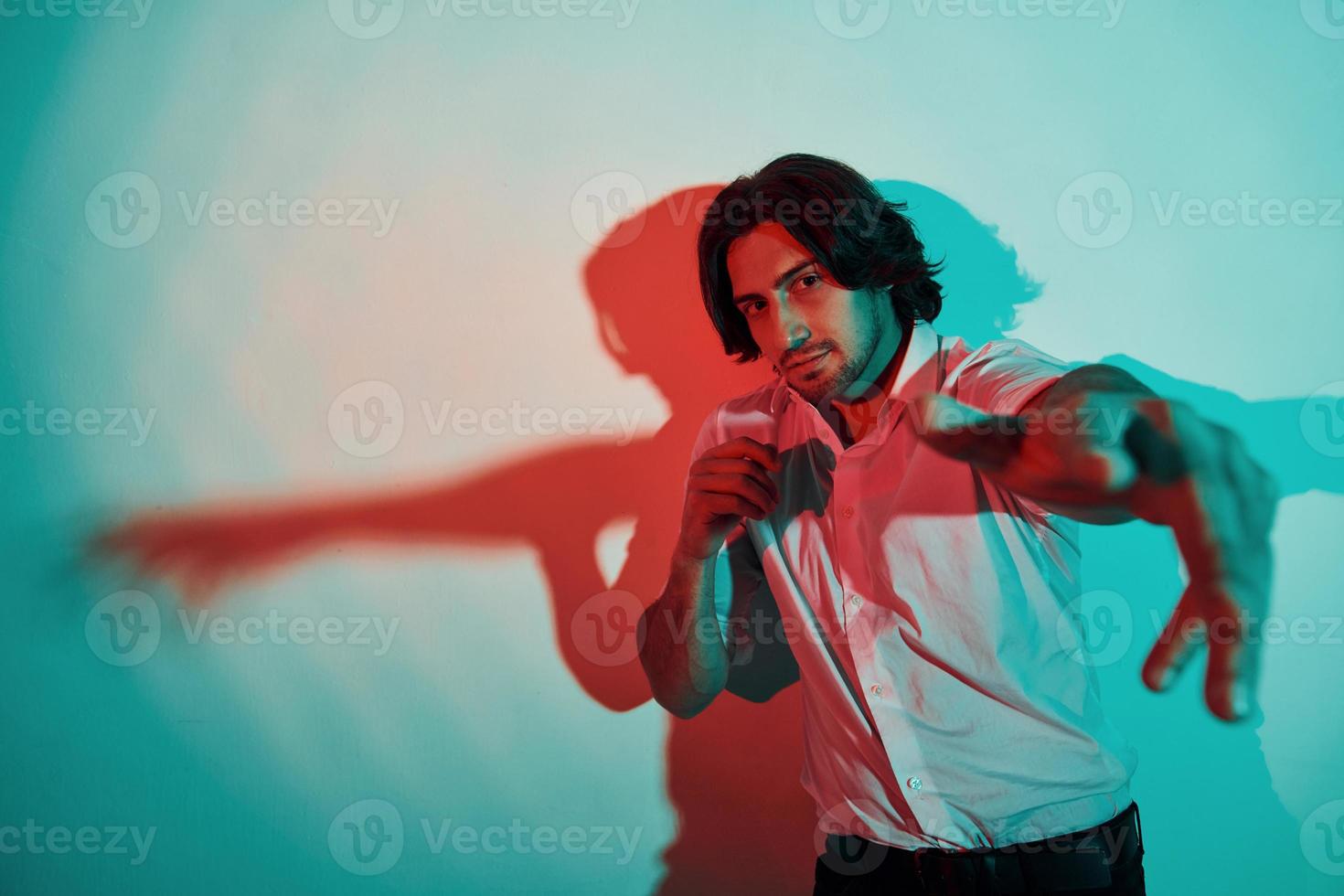 portrait de jeune homme élégant qui se tient dans des néons dans le studio photo