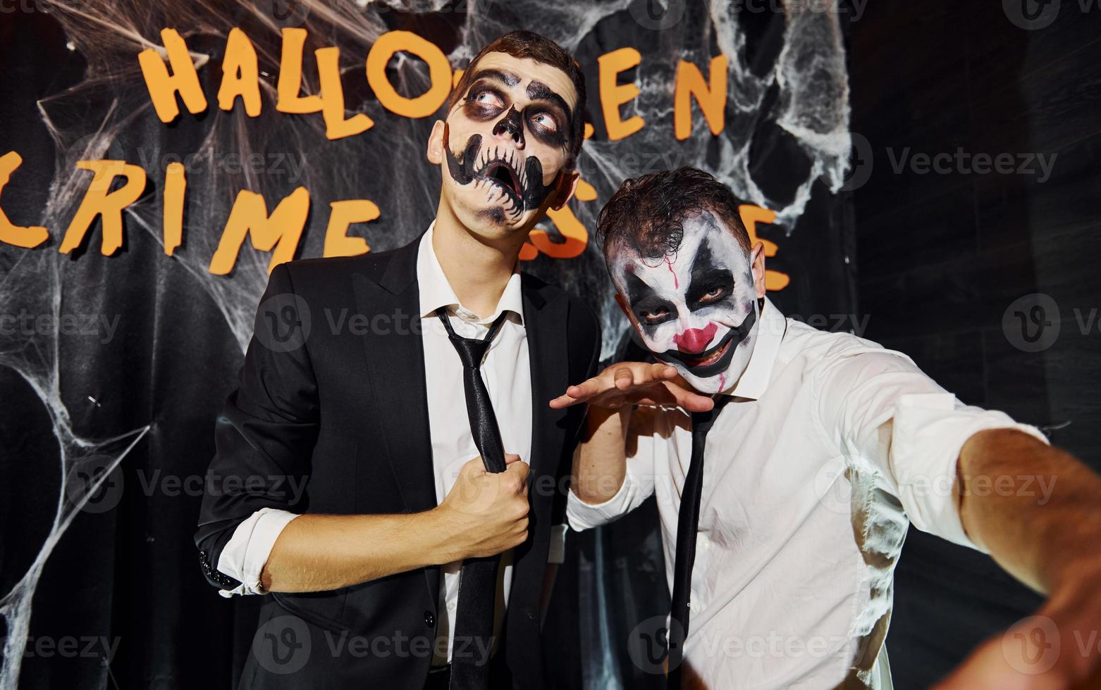 des amis sont à la fête d'halloween thématique avec un maquillage effrayant et des costumes criant à la caméra photo