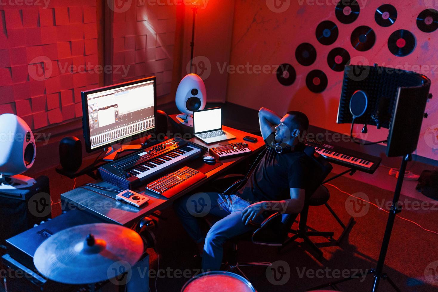 ingénieur du son travaillant et mixant de la musique à l'intérieur dans le studio près du kit de batterie photo