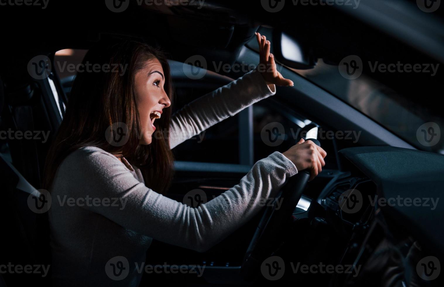 vue latérale d'une jeune femme à l'intérieur d'une toute nouvelle automobile moderne photo