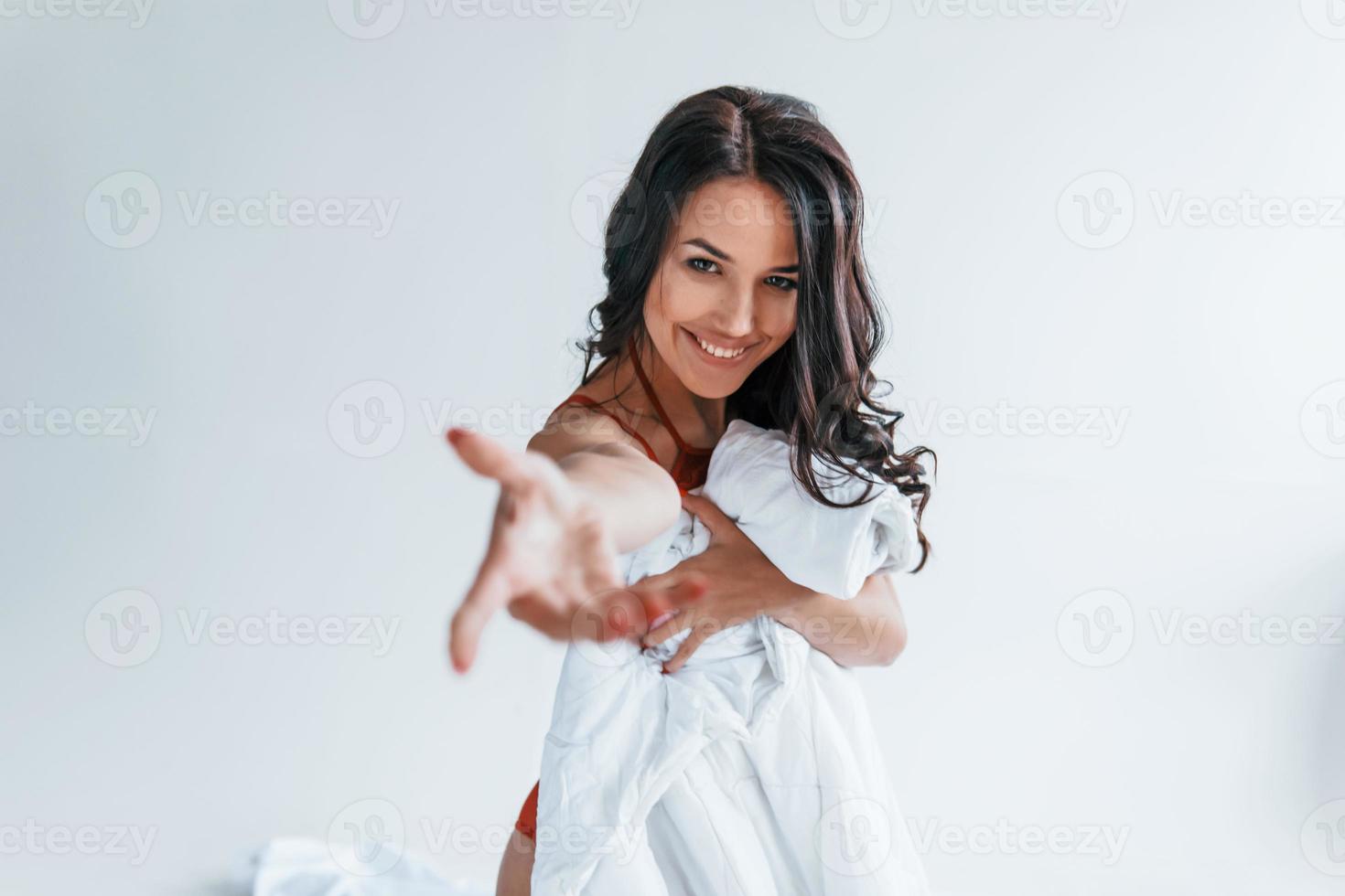 belle jeune brune en sous-vêtements debout en studio et couvrant son corps sexy par une serviette blanche photo