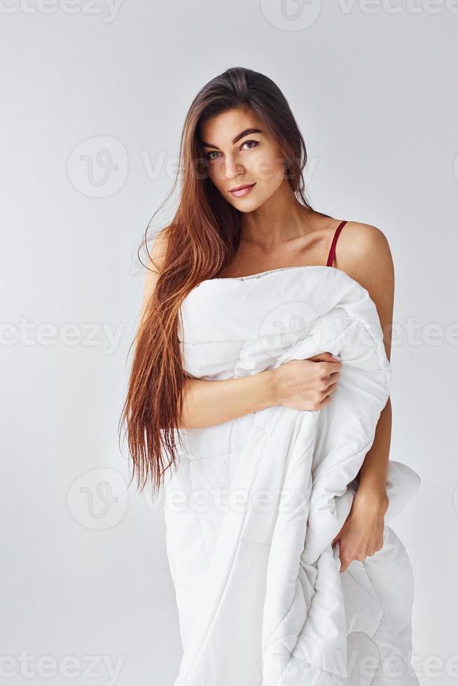 femme couvrant son corps par une serviette dans le studio sur fond blanc photo