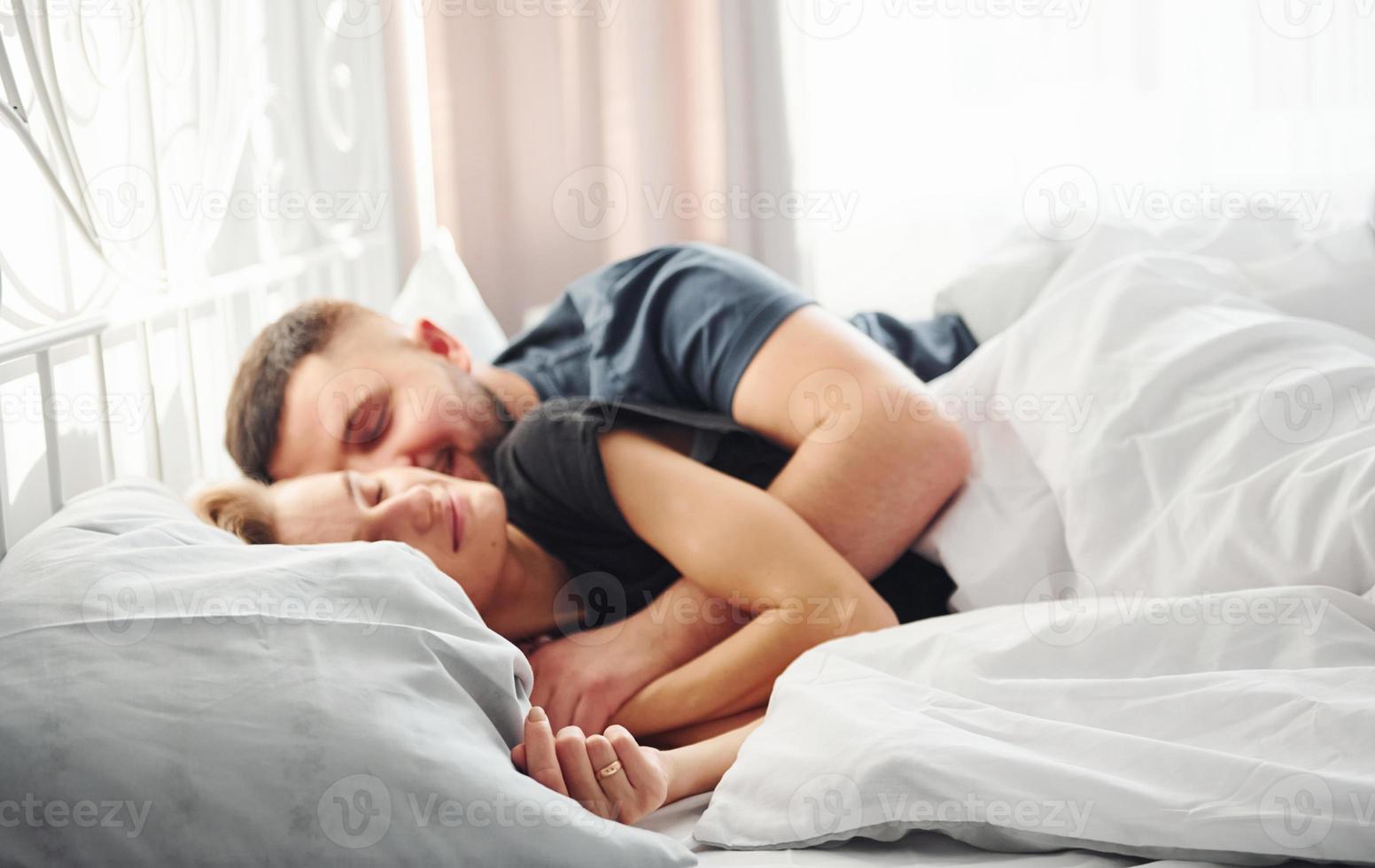 mignon jeune couple allongé sur le lit et dormir ensemble photo