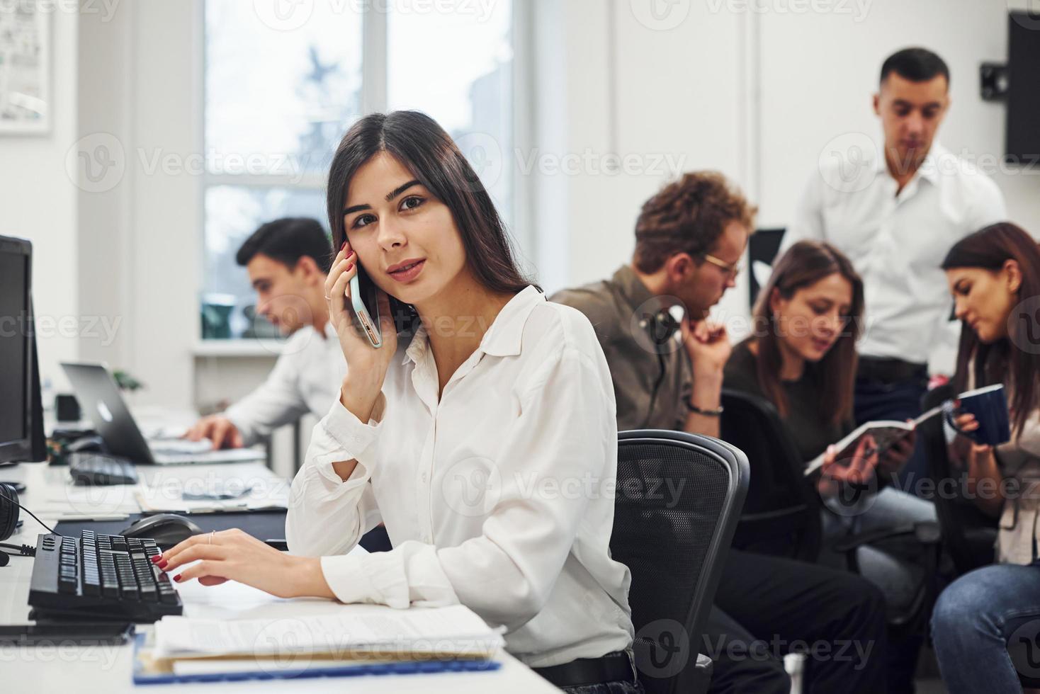 femme a un appel. jeunes gens d'affaires travaillant ensemble dans le bureau moderne photo