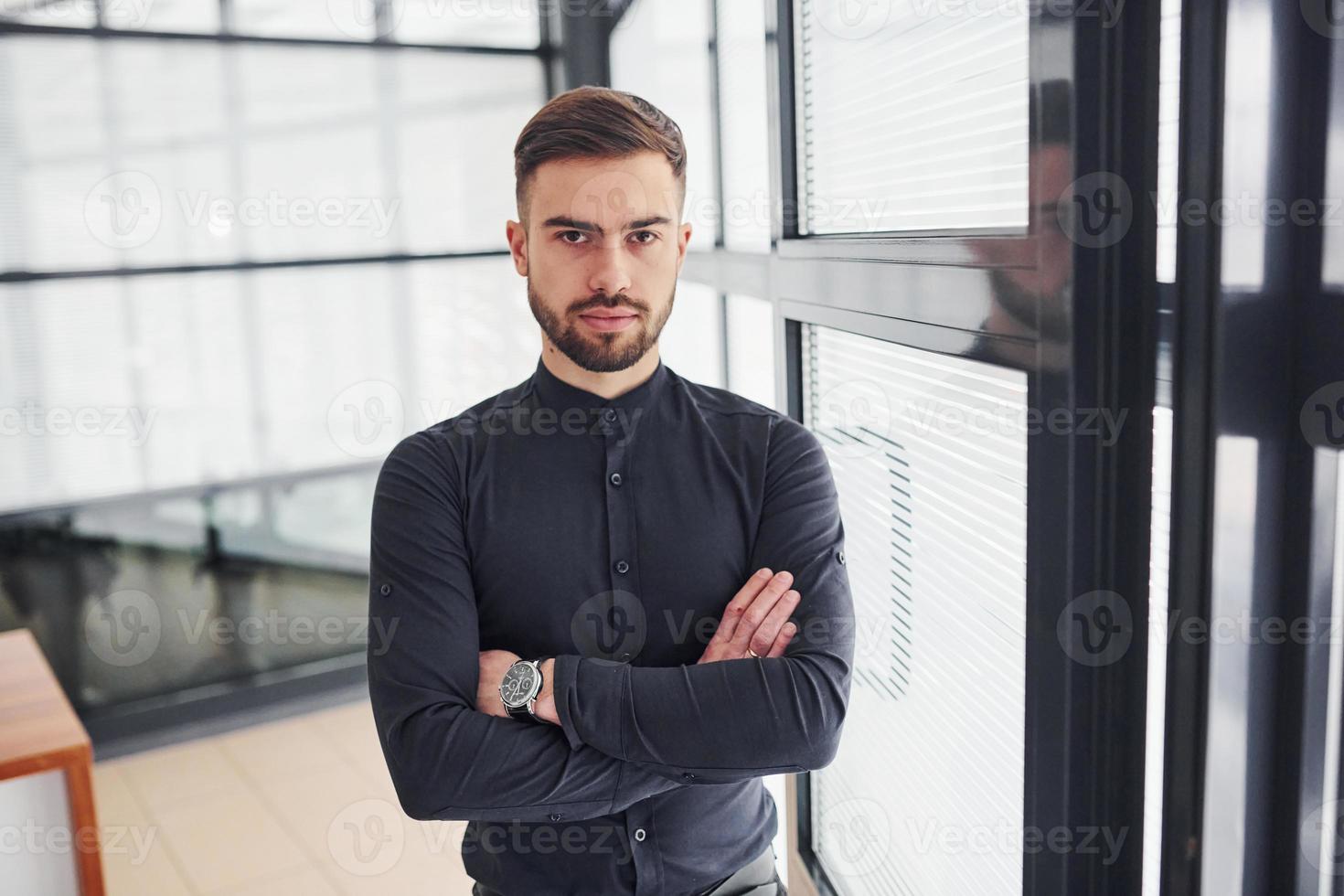 employé de bureau en vêtements formels debout à l'intérieur pendant la journée photo