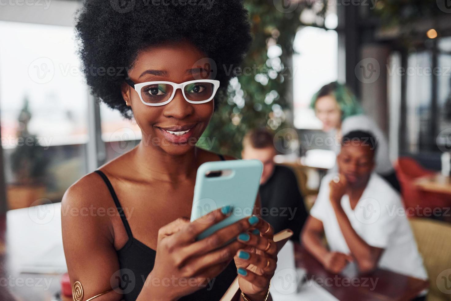 femme noire debout devant un groupe de personnes multiethniques avec une fille alternative aux cheveux verts travaille ensemble près de la table à l'intérieur photo