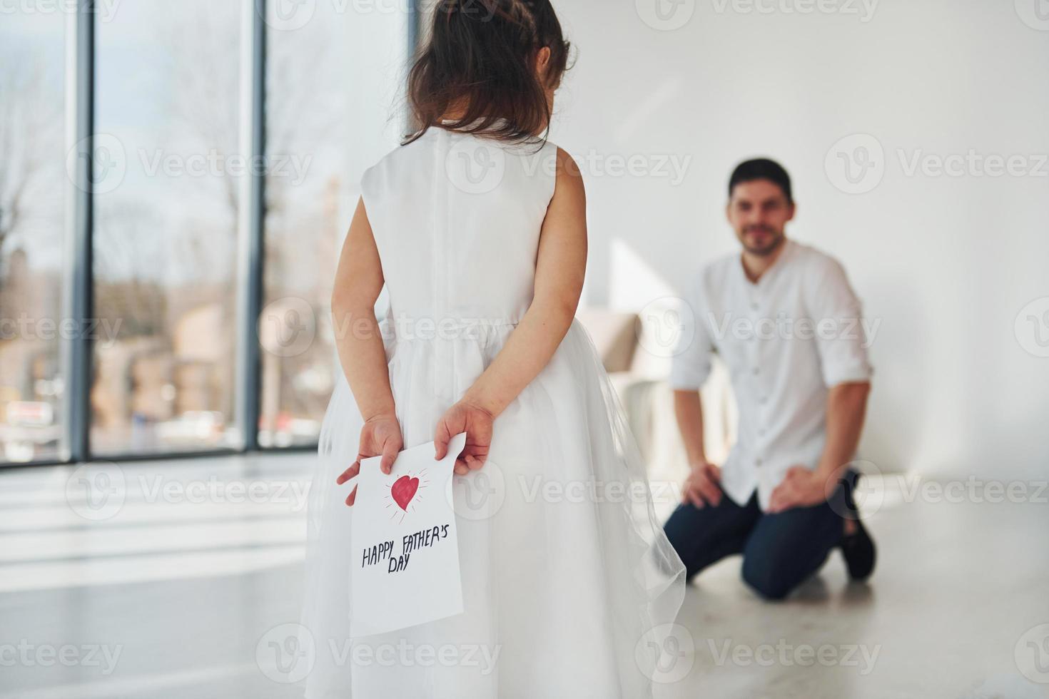 joyeuse fête des Pères. fille fait une surprise pour papa en donnant une carte postale avec coeur photo