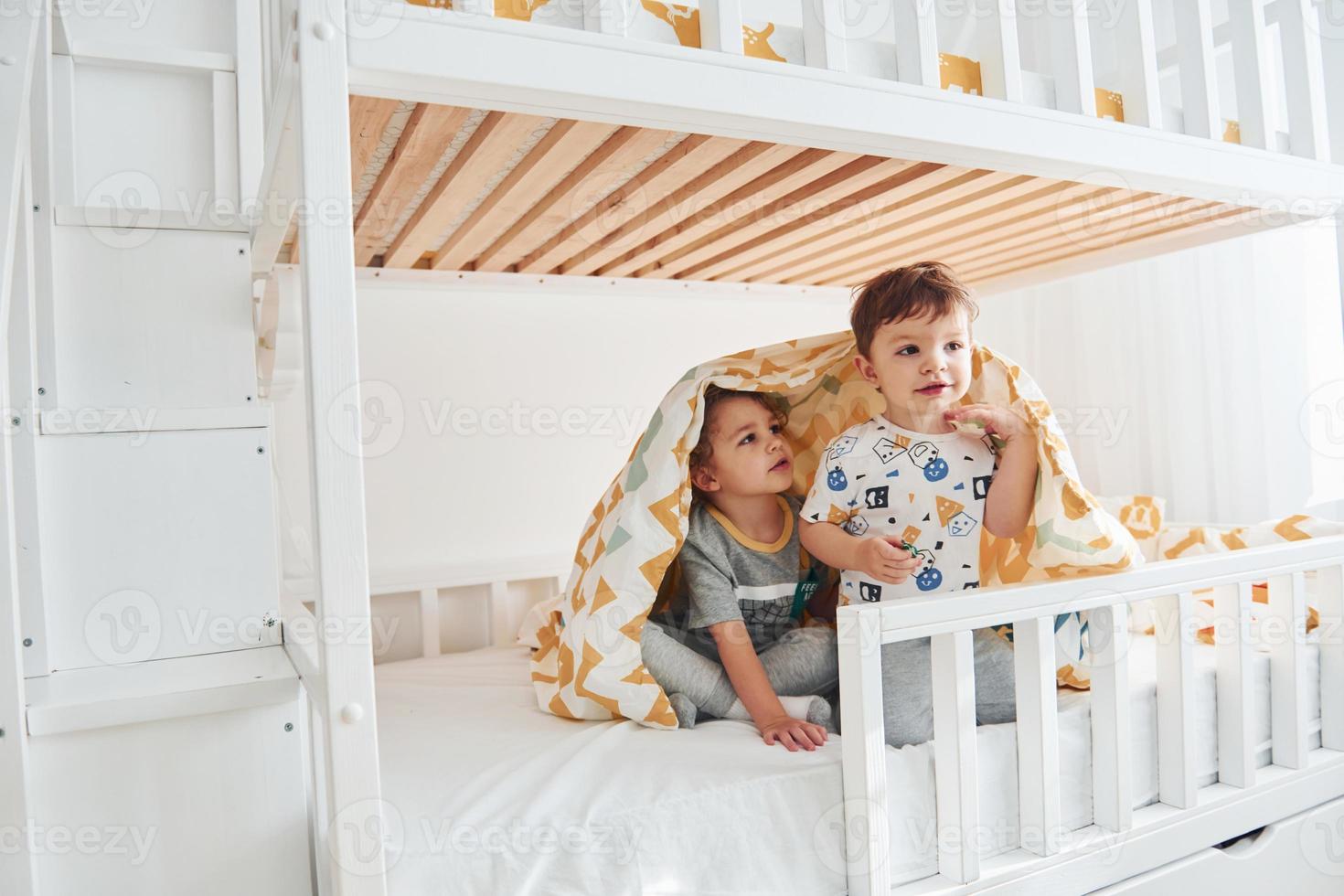 deux petits garçons se reposent et s'amusent ensemble dans la chambre à coucher photo