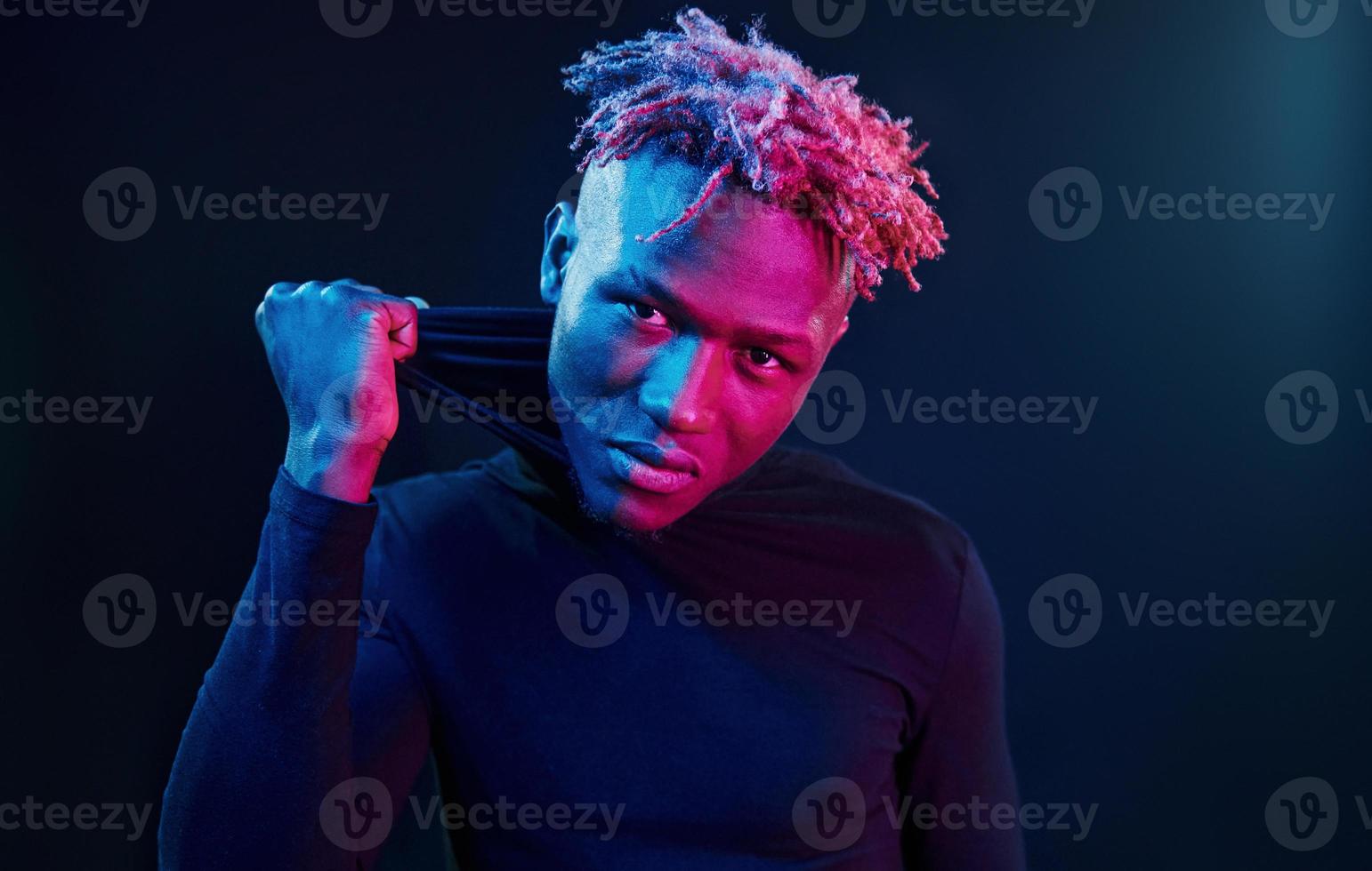 éclairage néon futuriste. jeune homme afro-américain dans le studio photo