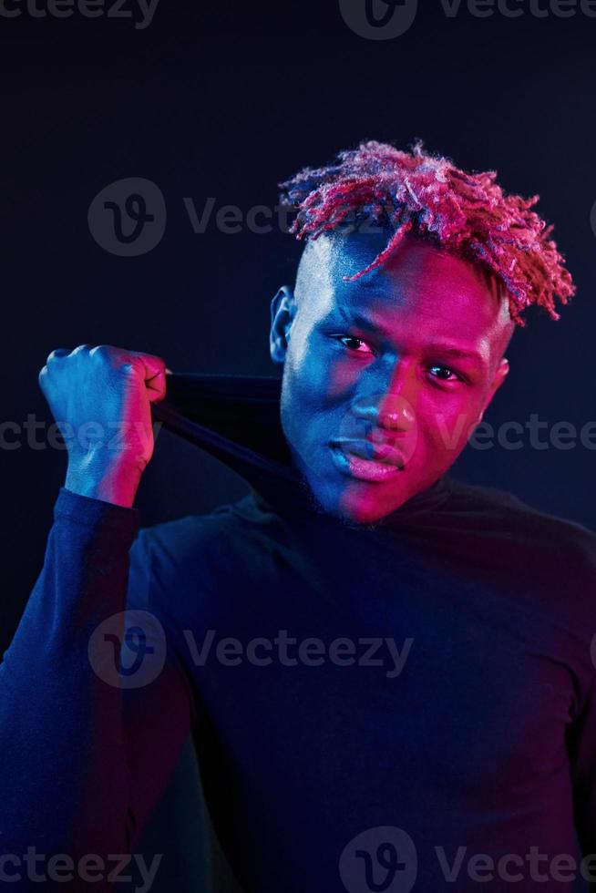 éclairage néon futuriste. jeune homme afro-américain dans le studio photo