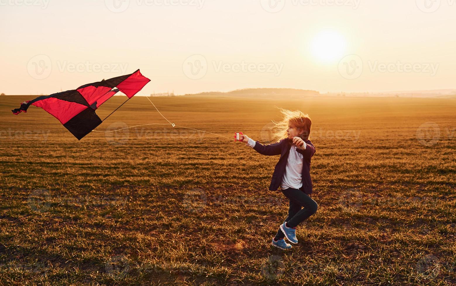 un enfant heureux lance un cerf-volant sur le terrain au coucher du soleil.  petit garçon et fille en vacances d'été 3673210 Photo de stock chez Vecteezy