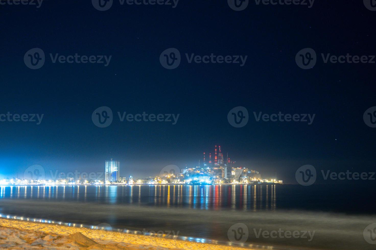 la plage de mazatlan sinaloa la nuit avec une ville lumineuse en arrière-plan photo