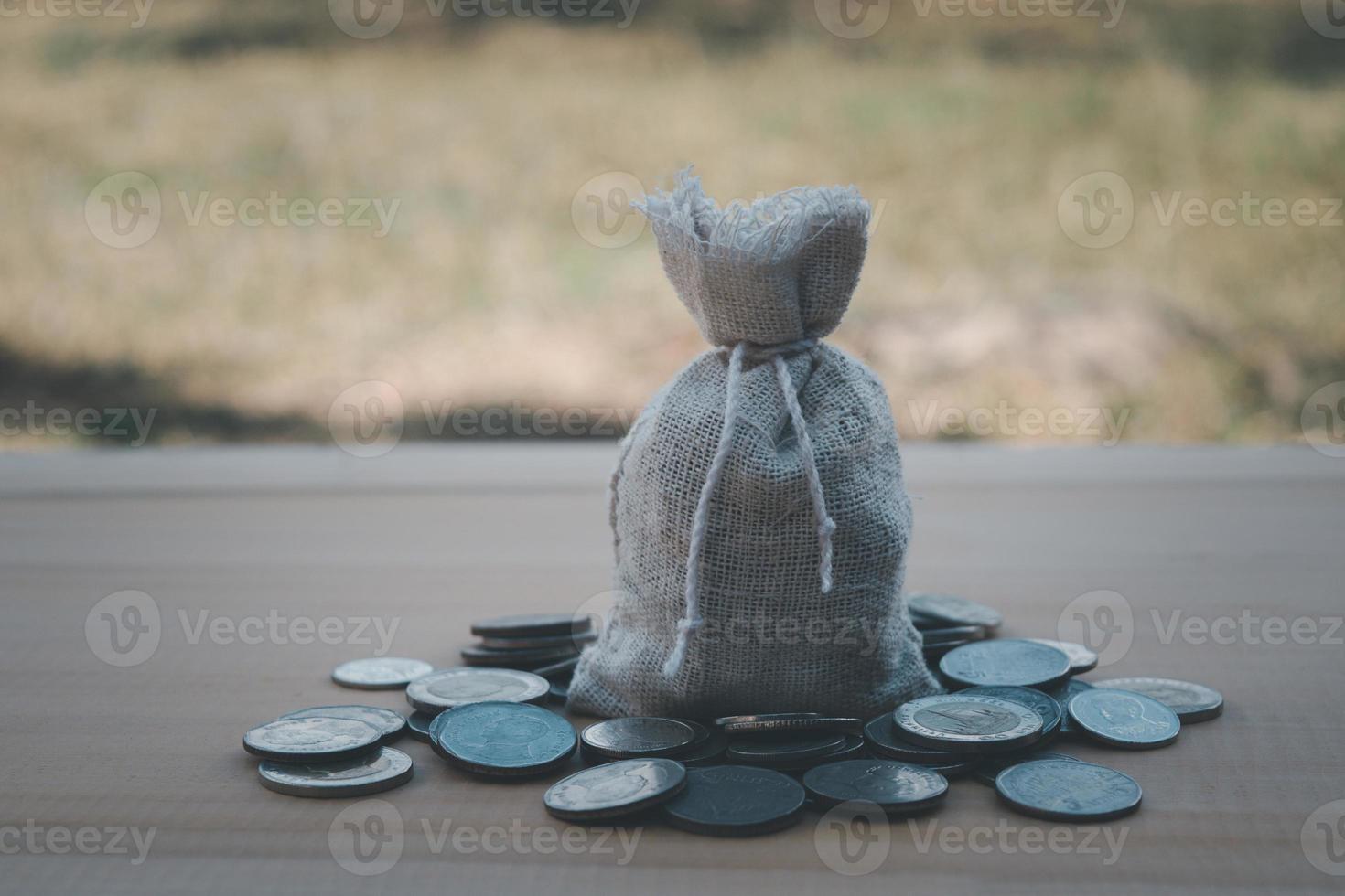 sac d'argent autour de pièce de monnaie sur la table en bois arrière-plan flou photo