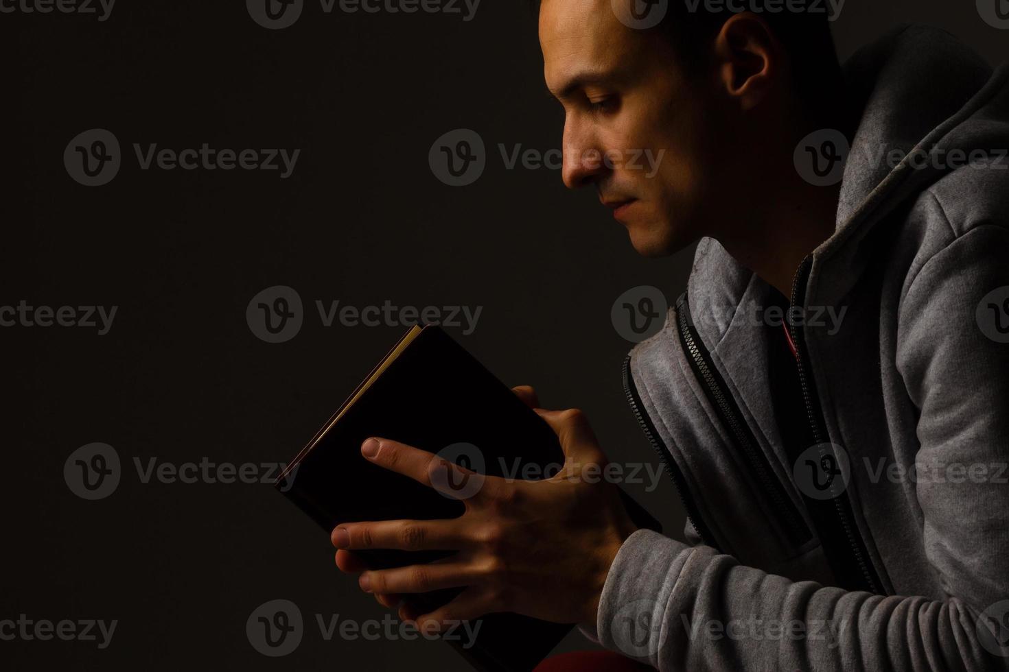 un homme priant tenant une sainte bible. photo