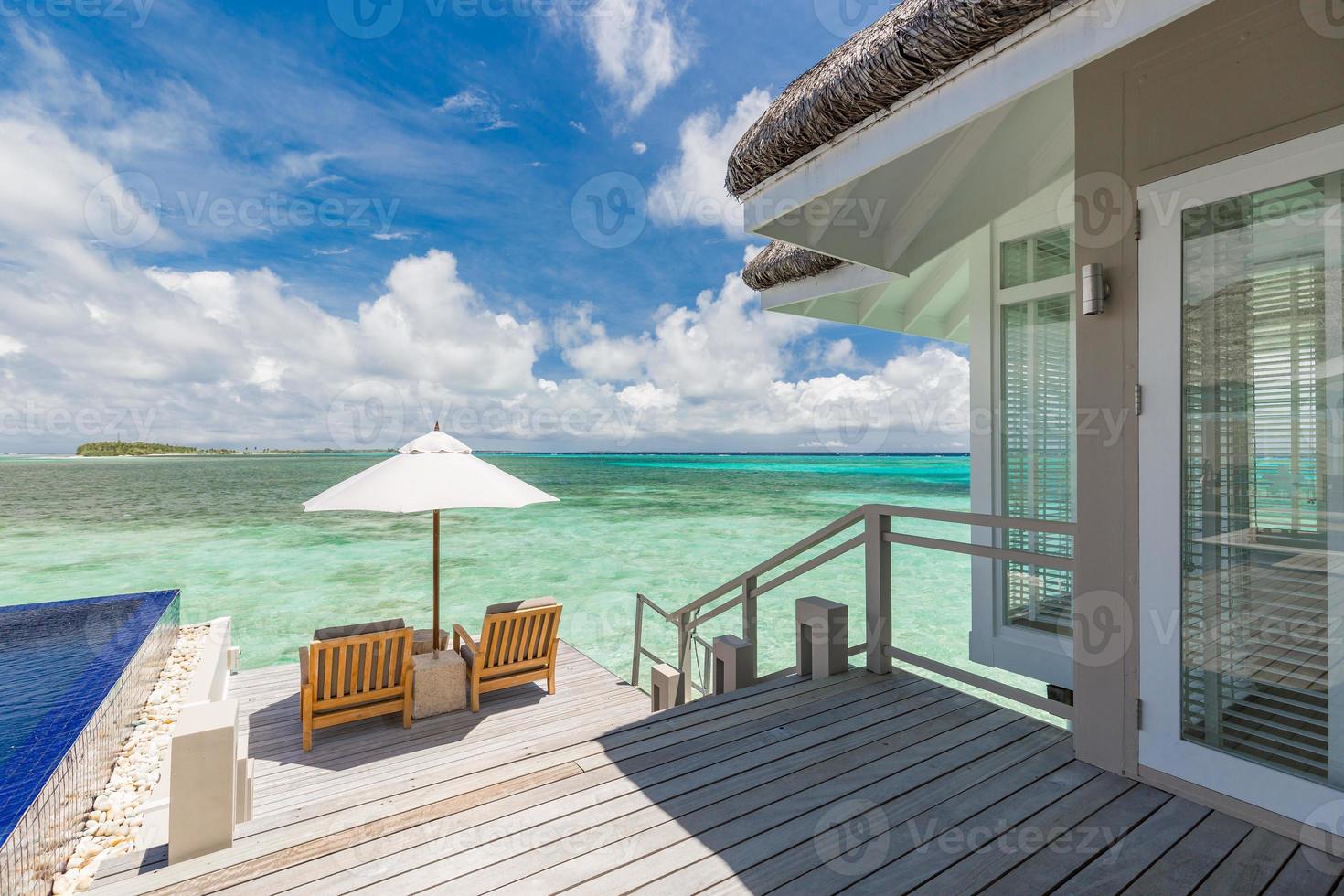 voyages et vacances d'été de luxe. beau paysage de ciel au bord de la piscine et au coucher du soleil. paysage de plage tropicale luxueux, chaises longues et chaises longues et réflexion de l'eau. photo