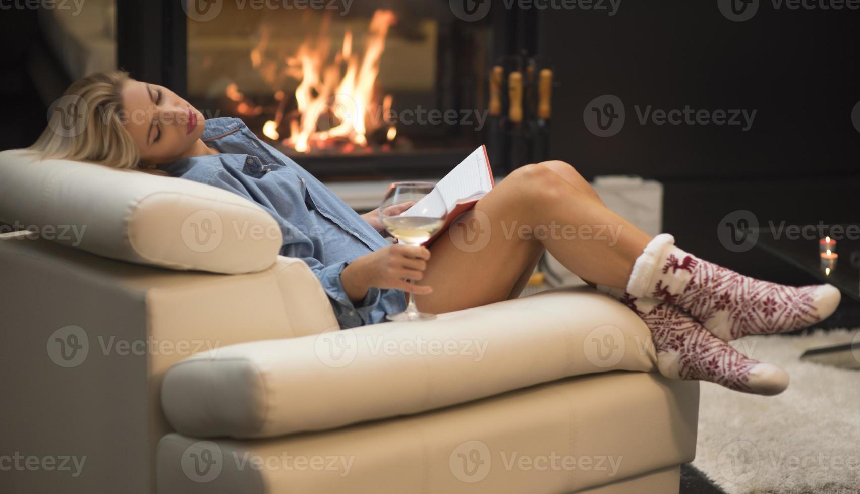 belle femme lisant un livre assis sur le canapé. photo